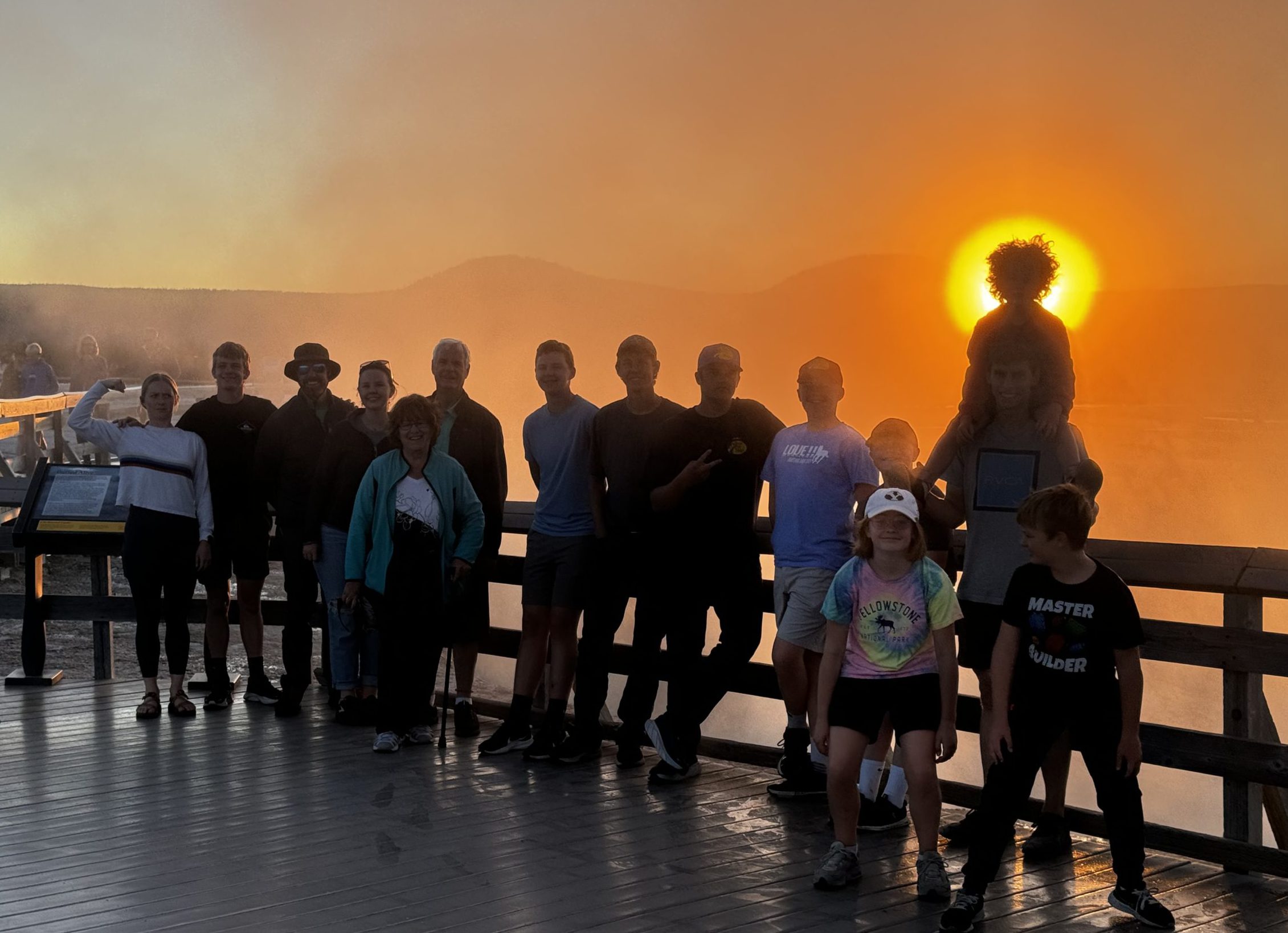 Family silhouetted by the steam and sunset